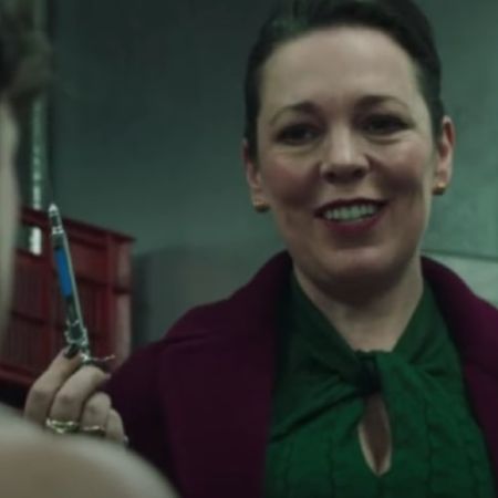 Olivia Coleman is holding a syringe threatening the man.